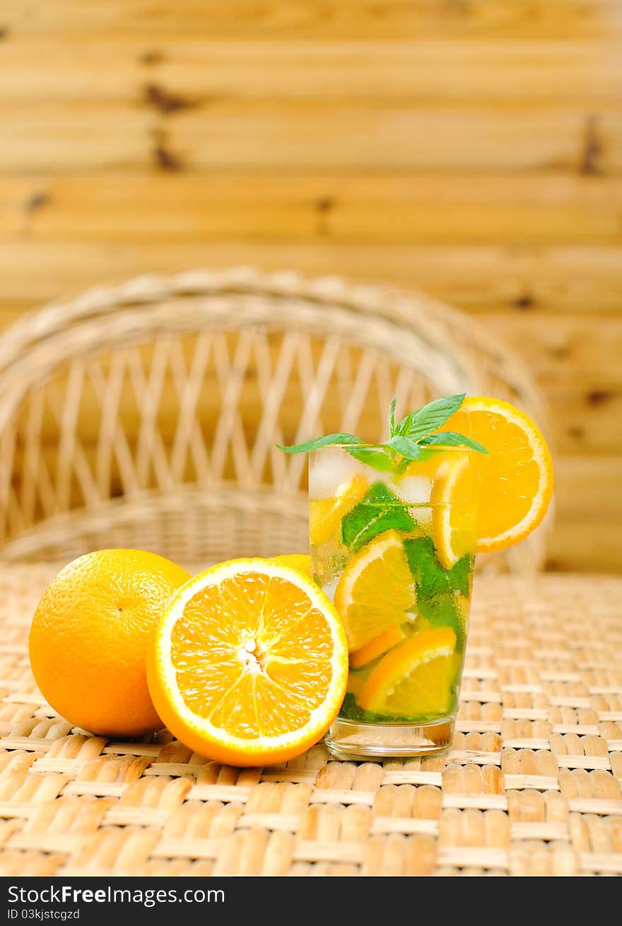 Glass of water with mint leaves and oranges on the table. Glass of water with mint leaves and oranges on the table