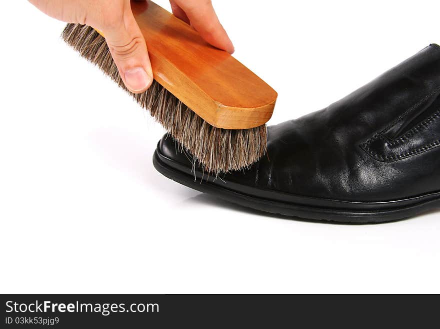 Hand with brush cleaning shoe isolated on white background