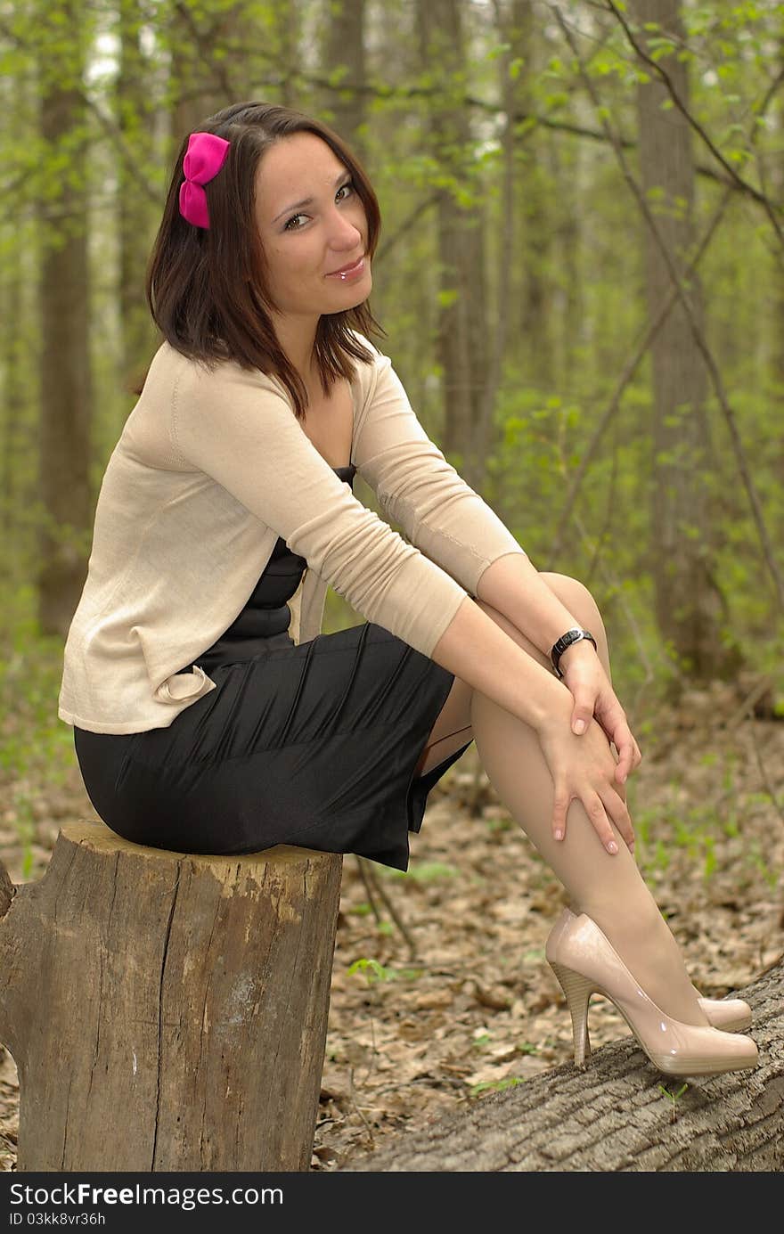 female sitting on a tree stump. female sitting on a tree stump