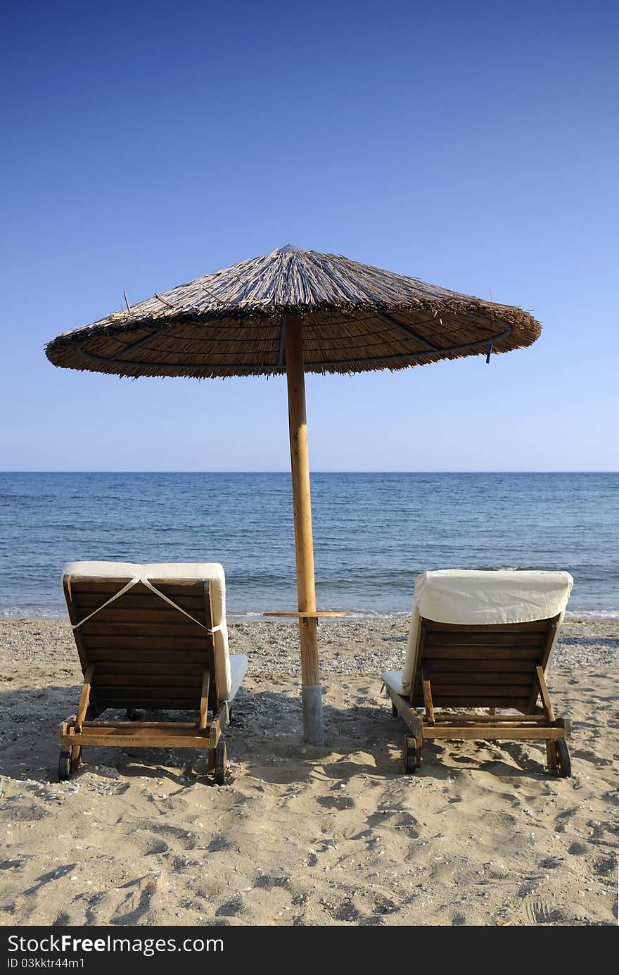 Umbrella And Two Chairs Over The Sea