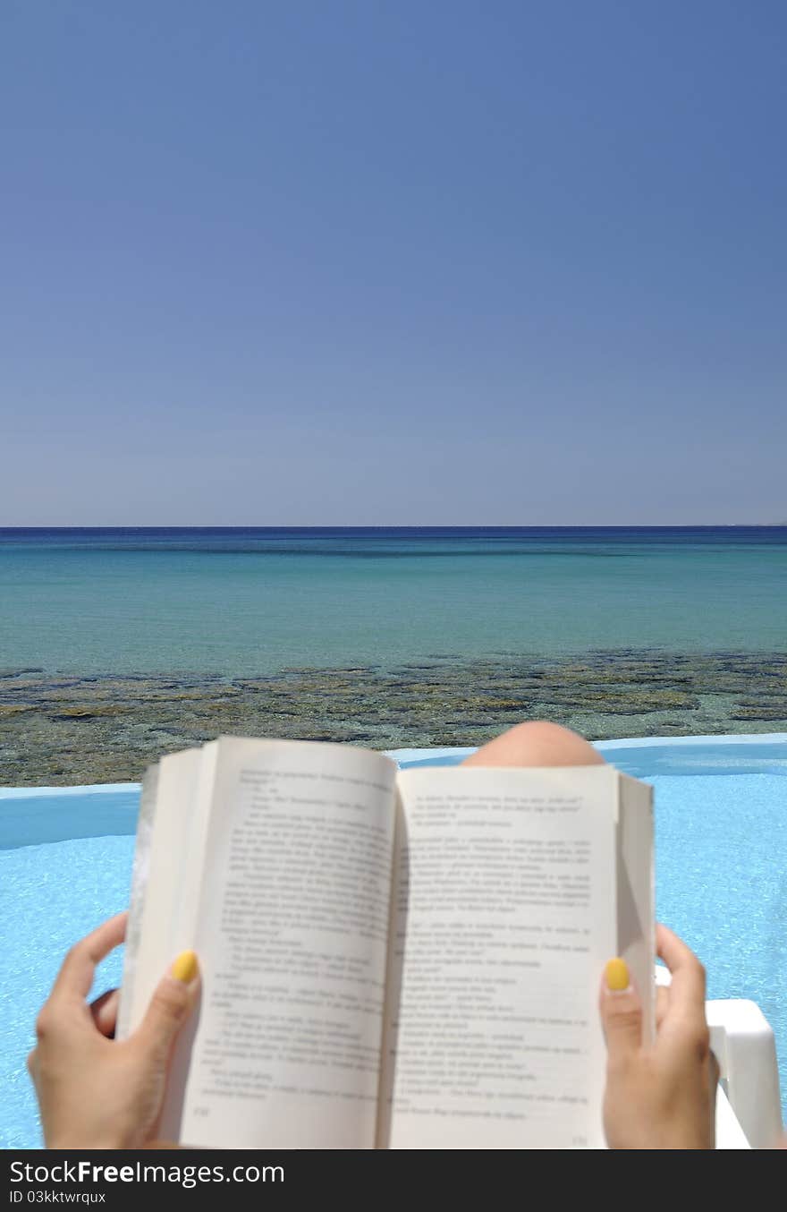 Girl reading a book over the sea