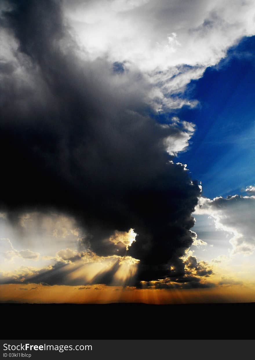 Sunset behind a cumulus formation with beautiful crepuscular rays. Sunset behind a cumulus formation with beautiful crepuscular rays.