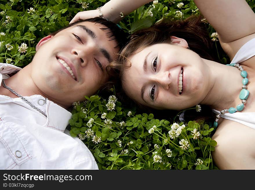 Man and the woman lay together on a grass. Man and the woman lay together on a grass