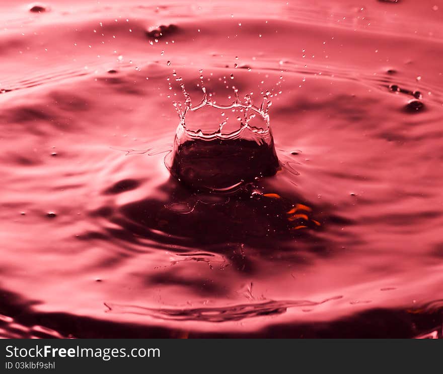 The splashing of red water and round drop of water