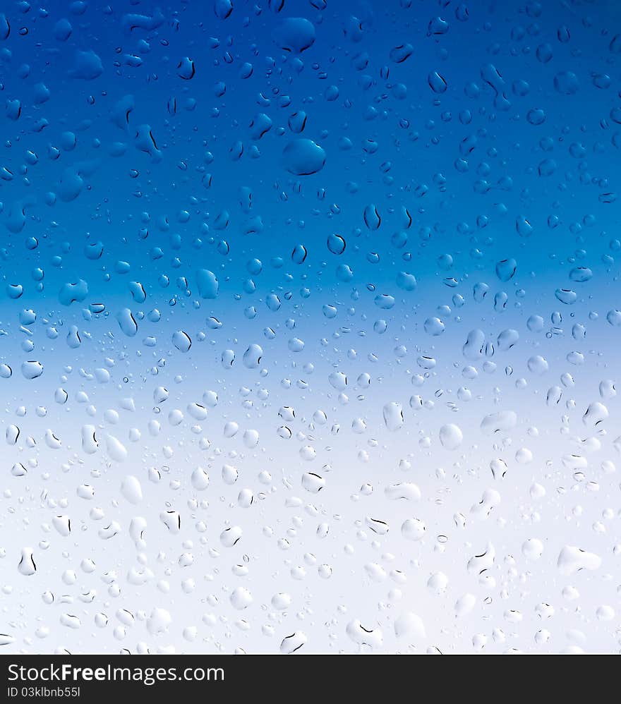 Blue and white drops of water on glass