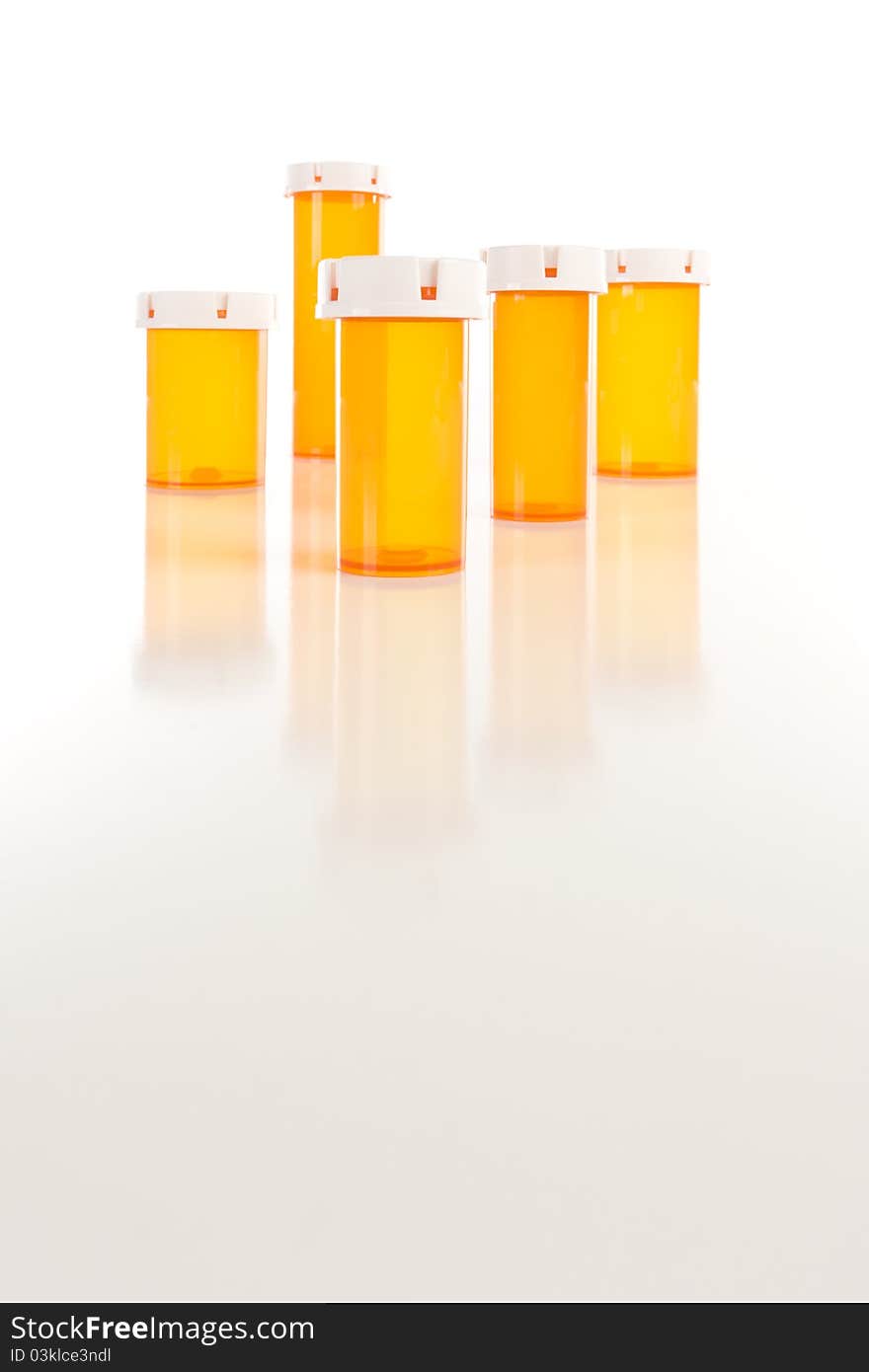 Several Different Sized Empty Medicine Bottles on Reflective Surface.