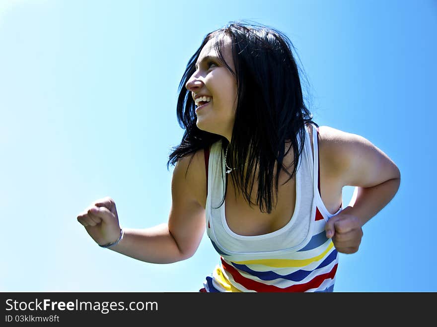 Young girl posing on blue background formed by the sky. Young girl posing on blue background formed by the sky