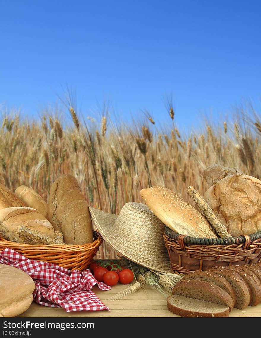 Various types of bread in front of a wheat field. Various types of bread in front of a wheat field