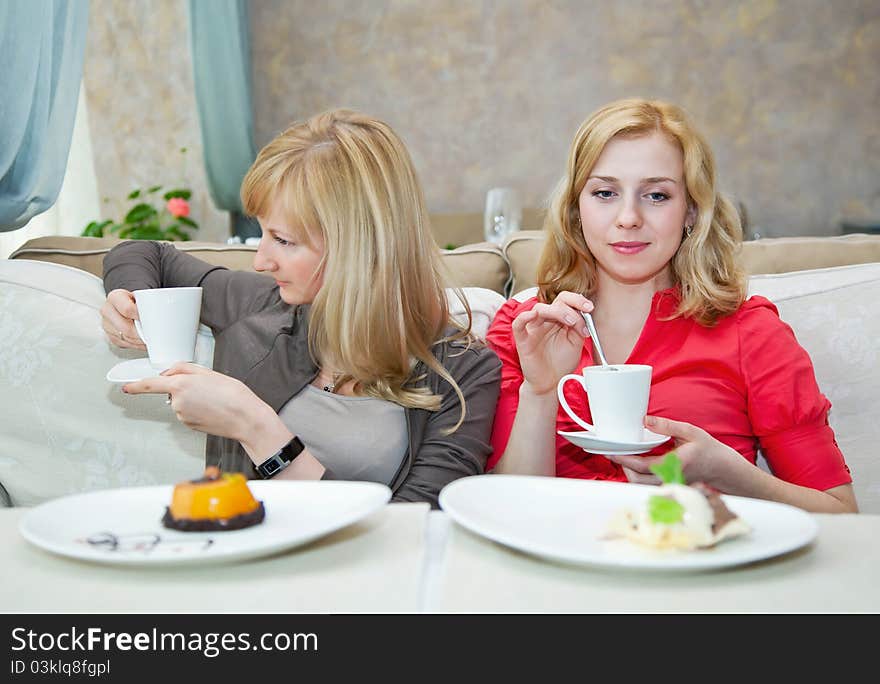 Two young girls are drinking tea in cafe. Two young girls are drinking tea in cafe