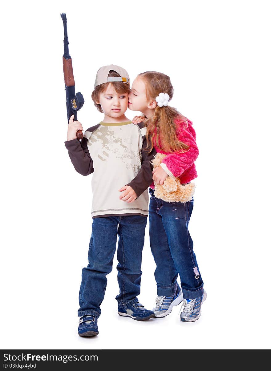 A girl is kissing a boy with the gun. Isolated on a white background