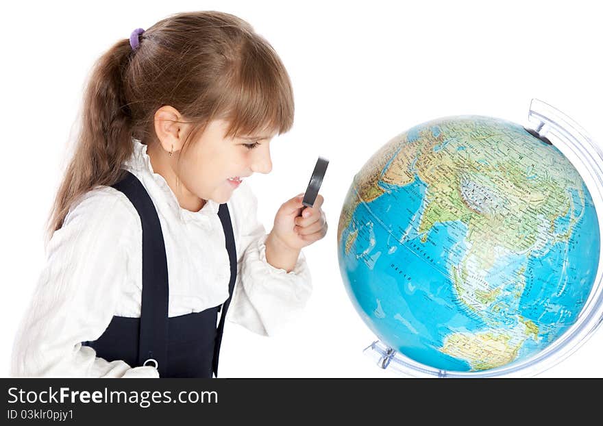 A girl is looking through the loupe at the globe. A girl is looking through the loupe at the globe