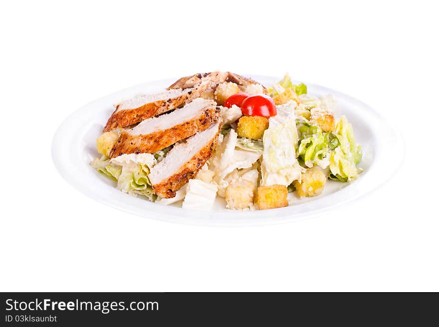 Caesar salad with chicken on a plate. On a white background.