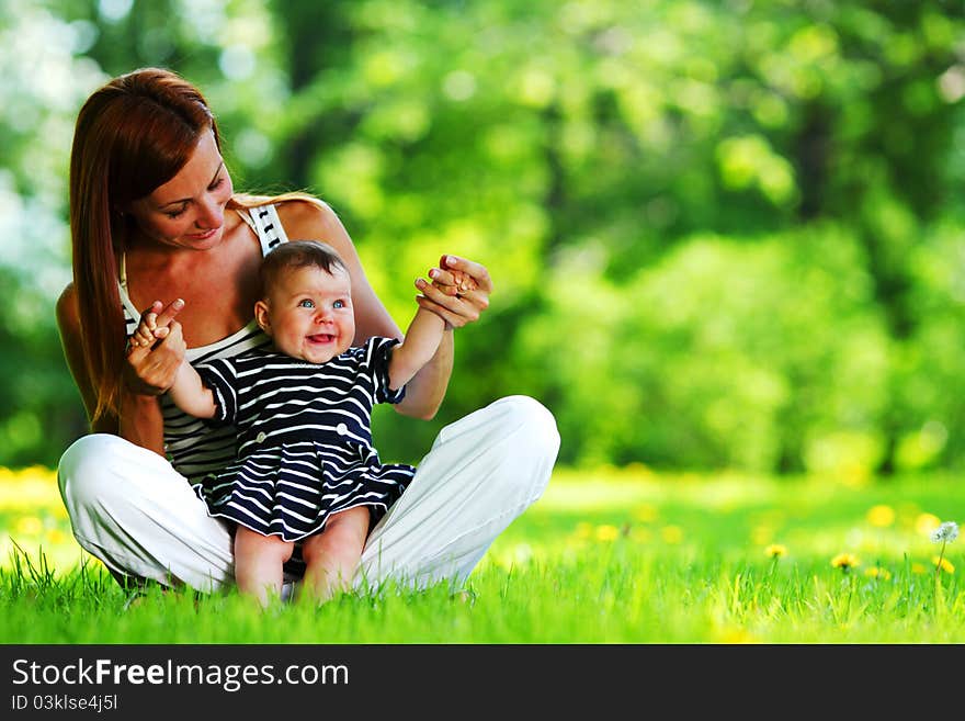 Mother and daughter on the green grass