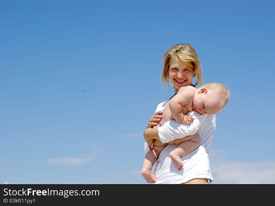 Happy mother and baby playing on sky background