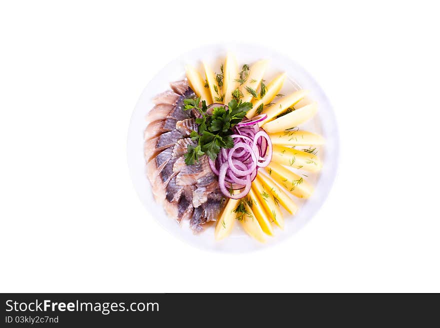 Sliced вЂ‹вЂ‹herring with potatoes and onions to a plate. Sliced вЂ‹вЂ‹herring with potatoes and onions to a plate.