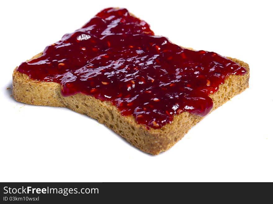 Close view of a toasted bread with berry jam spread  isolated on a white background. Close view of a toasted bread with berry jam spread  isolated on a white background.