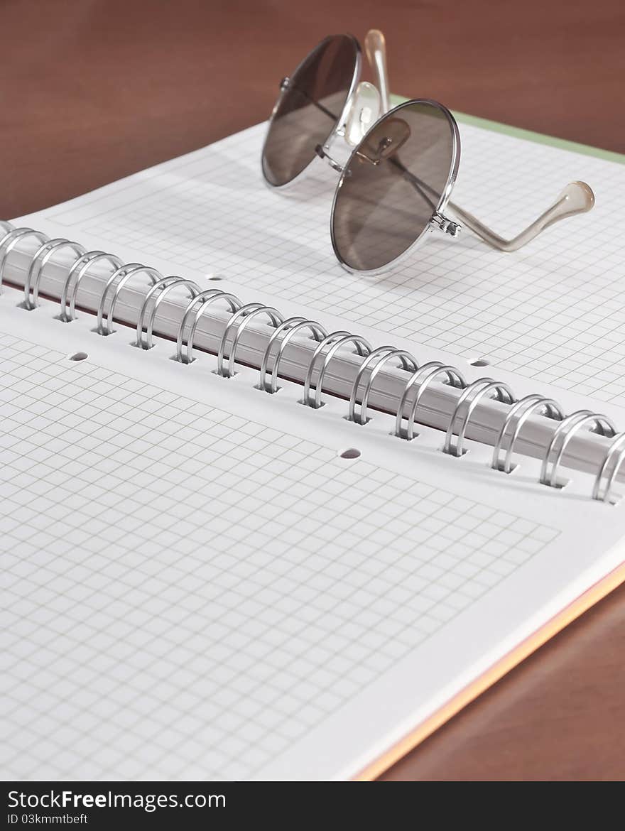 Open notebook and glasses on the table