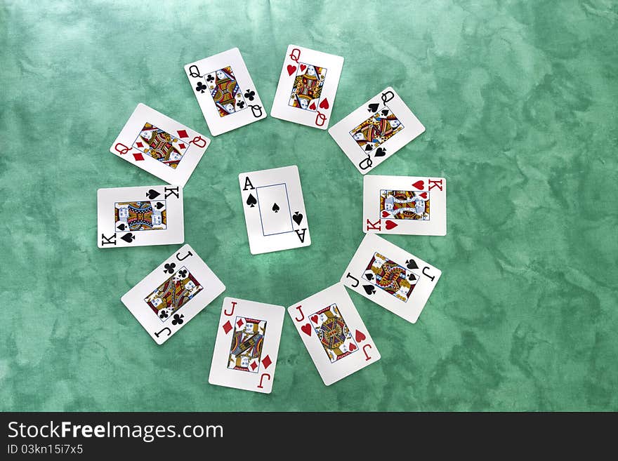 Close up view of a circle of playing cards spread on a green cloth table. Close up view of a circle of playing cards spread on a green cloth table.