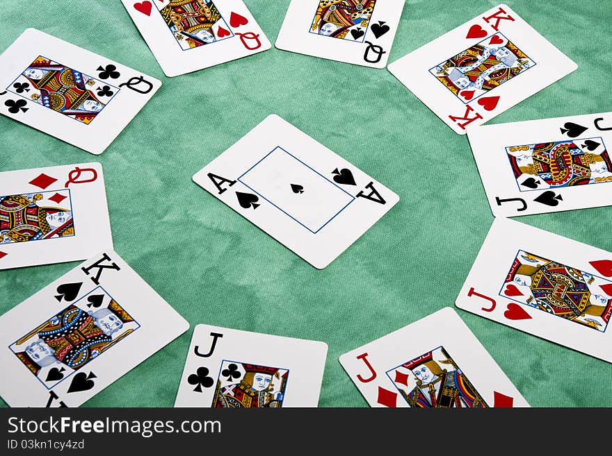 Close up view of a circle of playing cards spread on a green cloth table. Close up view of a circle of playing cards spread on a green cloth table.