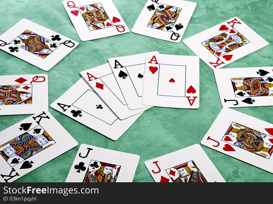 Close up view of a circle of playing cards spread on a green cloth table. Close up view of a circle of playing cards spread on a green cloth table.