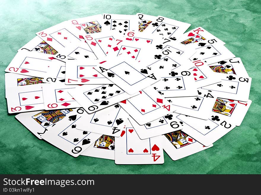 Close up view of a bunch cards spread on a green cloth table forming a circle. Close up view of a bunch cards spread on a green cloth table forming a circle.