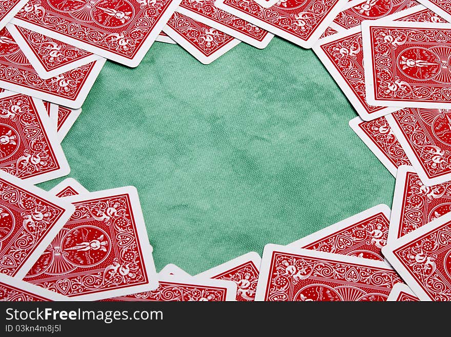 Close up view of a bunch of flipped playing cards spread on a green cloth table. Close up view of a bunch of flipped playing cards spread on a green cloth table.