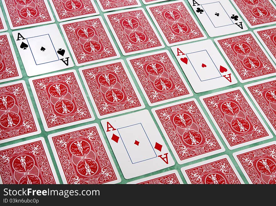 Close up view of a bunch of flipped playing cards spread on a green cloth table. Close up view of a bunch of flipped playing cards spread on a green cloth table.