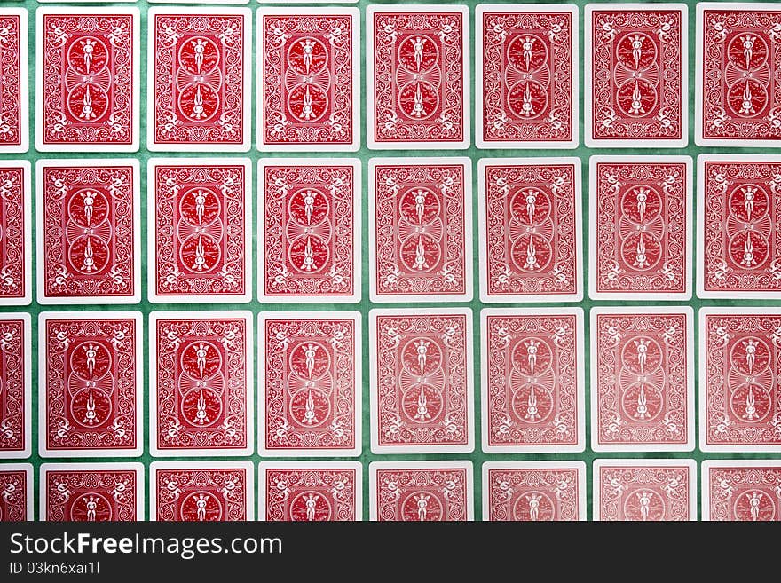 Close up view of a bunch of flipped playing cards spread on a green cloth table. Close up view of a bunch of flipped playing cards spread on a green cloth table.