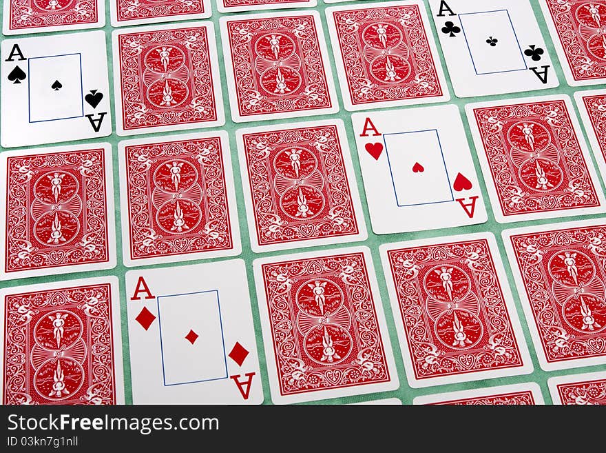 Close up view of a bunch of flipped playing cards spread on a green cloth table. Close up view of a bunch of flipped playing cards spread on a green cloth table.