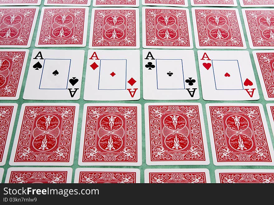 Close up view of a bunch of flipped playing cards spread on a green cloth table. Close up view of a bunch of flipped playing cards spread on a green cloth table.