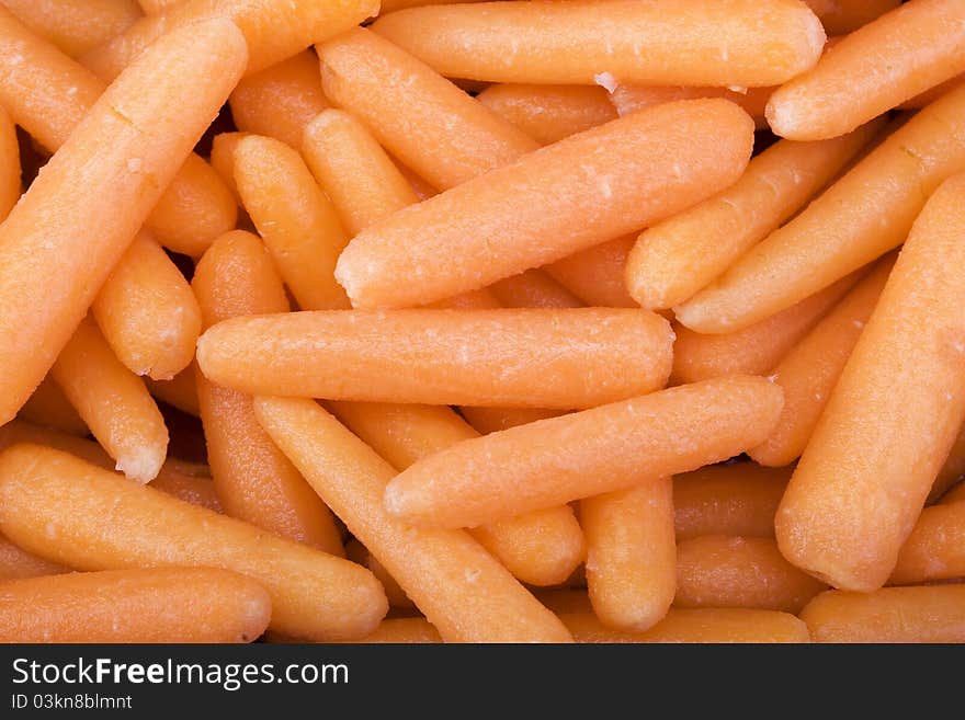 Raw baby carrots closeup macro background.