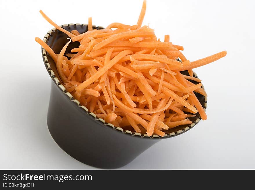 Shredded raw carrots in a ceramic bowl