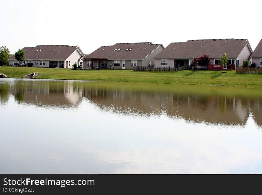 Several suburban duplex houses reflecting onto a lake. Several suburban duplex houses reflecting onto a lake