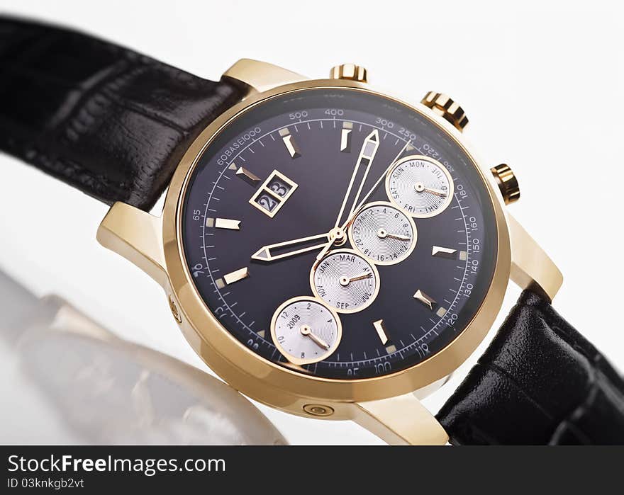 Gold men's wristwatch with black leather strap on a white background