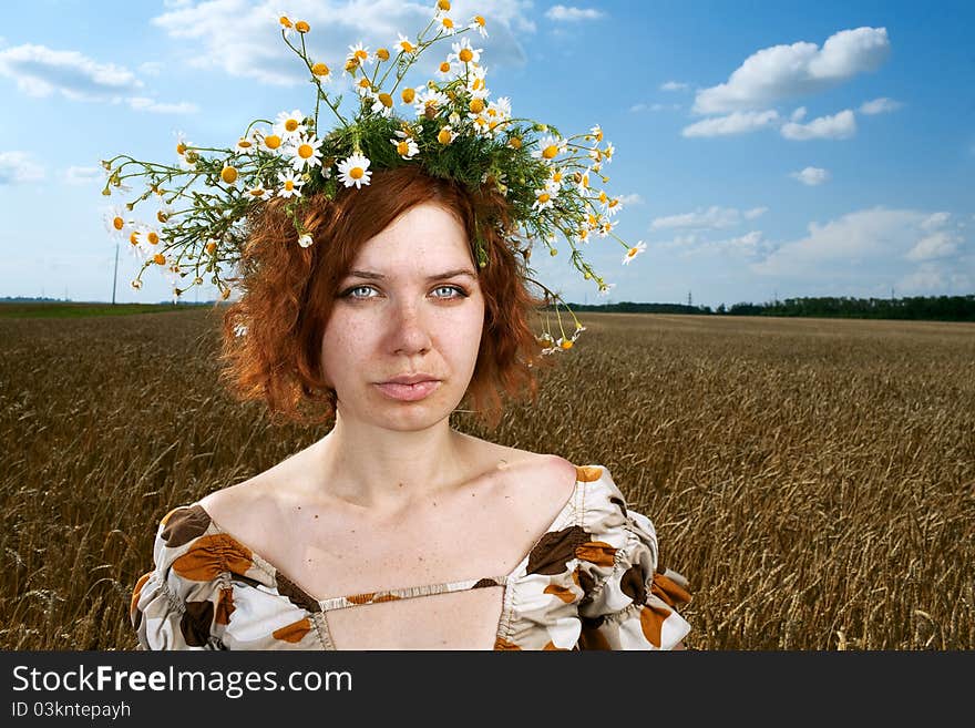 Woman in wheat field under blue sky