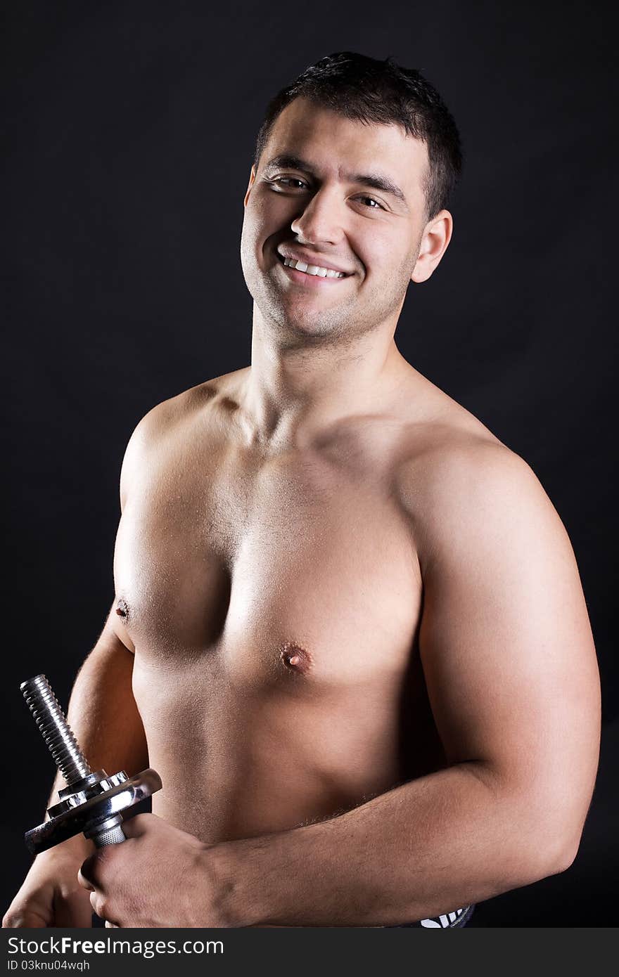 Athlete is holding a dumbbells and smiling. Athlete is holding a dumbbells and smiling