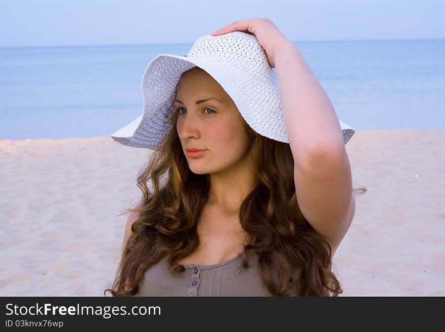 Portrait of woman wearing a hat from the sun on a blue background of the sea. Portrait of woman wearing a hat from the sun on a blue background of the sea