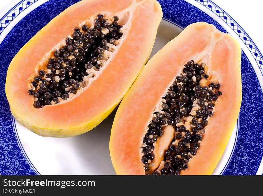 Close up view of papaya fruit sliced presented on a dish.