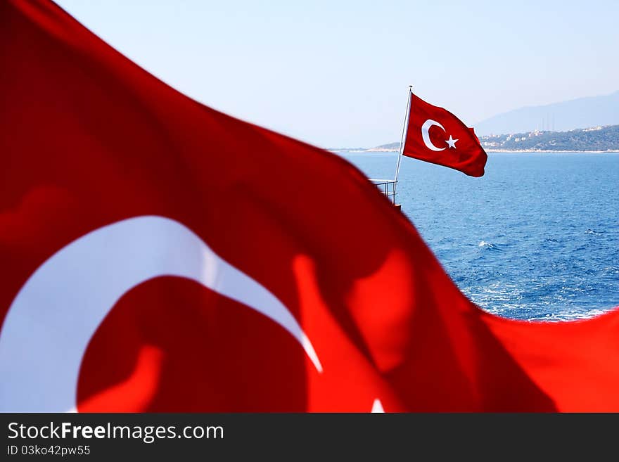 Image of two Turkish flags above sea