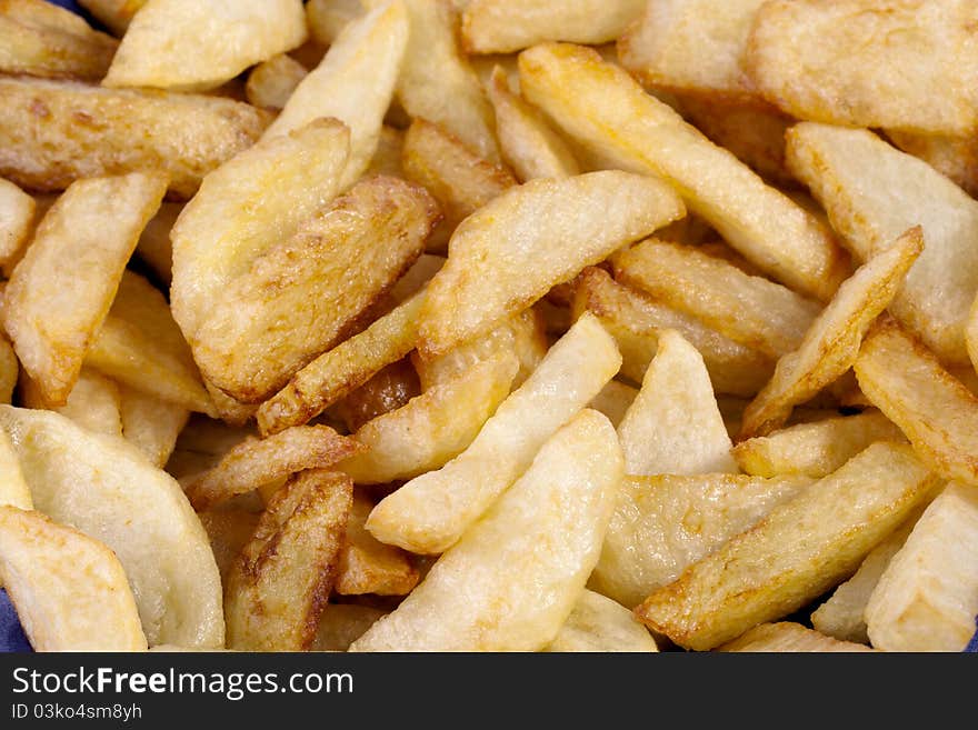 Close up view of a bunch of fried potatoes in slices.