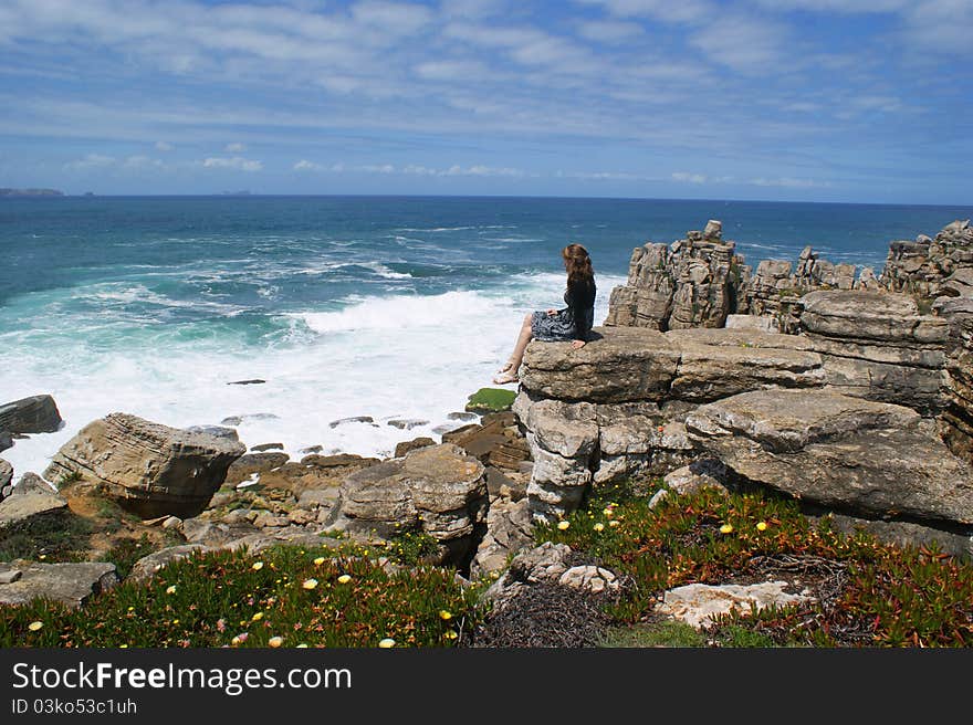 The coast of the Atlantic ocean, Portuguese landscape, tourism in Portugal, the girl on the shore of the ocean, rocky coast, the cliff above the ocean. The coast of the Atlantic ocean, Portuguese landscape, tourism in Portugal, the girl on the shore of the ocean, rocky coast, the cliff above the ocean