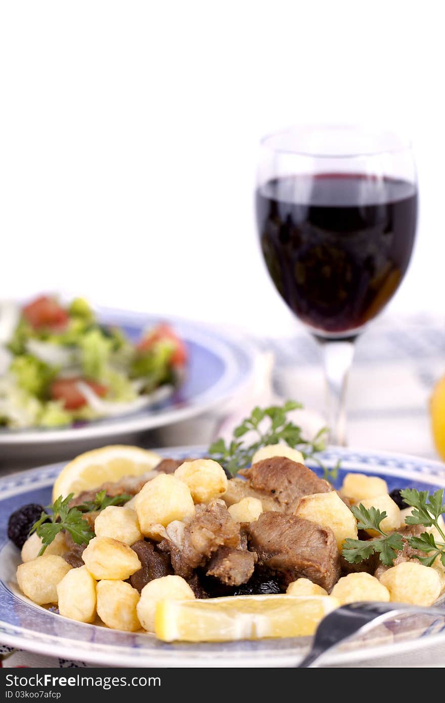 Close up view of a Portuguese meal of cooked meat with potatoes.