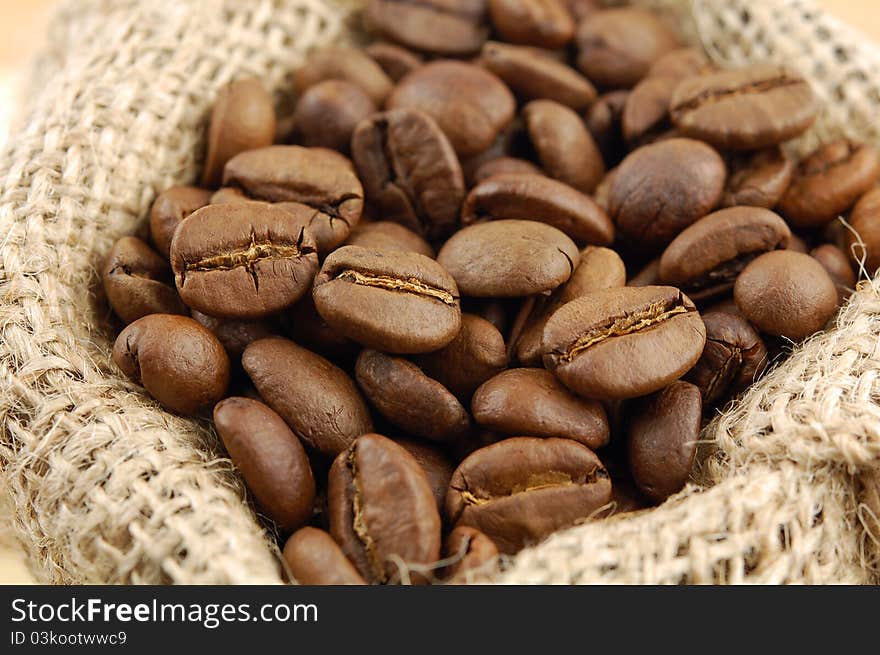 Roasted coffee beans in sacking bag. Selective focus.