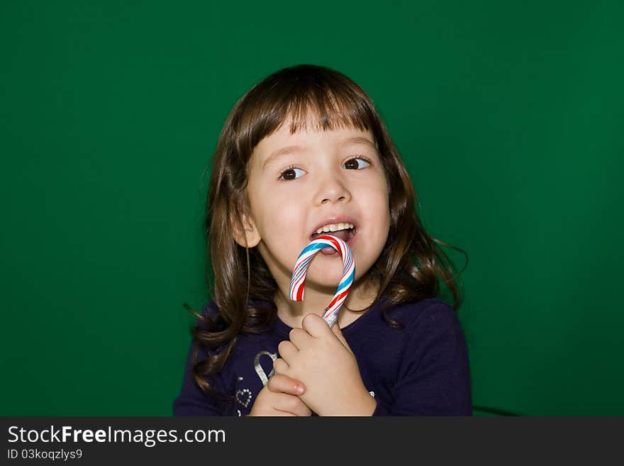 The girl on a green background with a sweet. The girl on a green background with a sweet