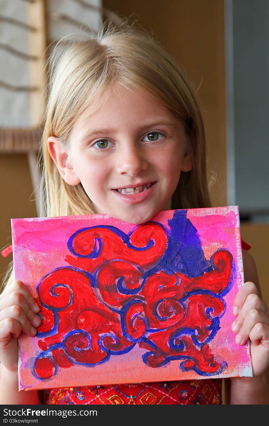 A young girl shows off her colorful painting. A young girl shows off her colorful painting