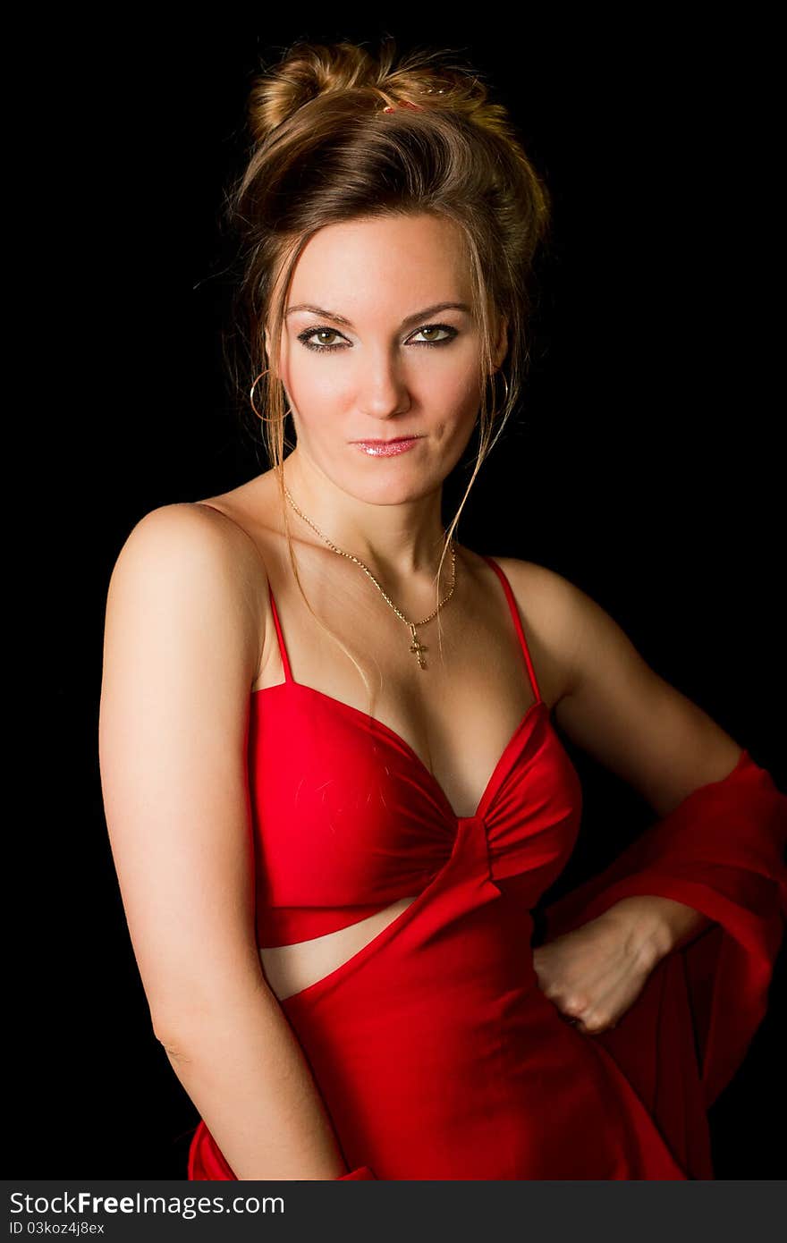 Beautiful woman with a passionate look in the red dress on a black background isolated. Beautiful woman with a passionate look in the red dress on a black background isolated