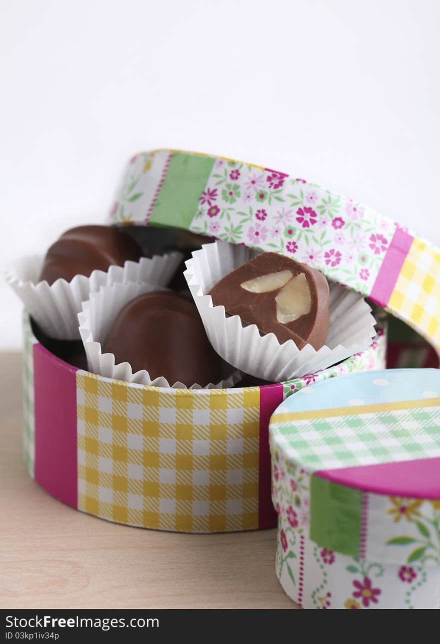 Chocolate truffles in colorful gift box on white background. Chocolate truffles in colorful gift box on white background.