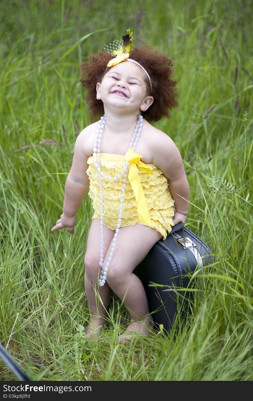 Happy little toddler girl wearing a yellow petti romper. Happy little toddler girl wearing a yellow petti romper