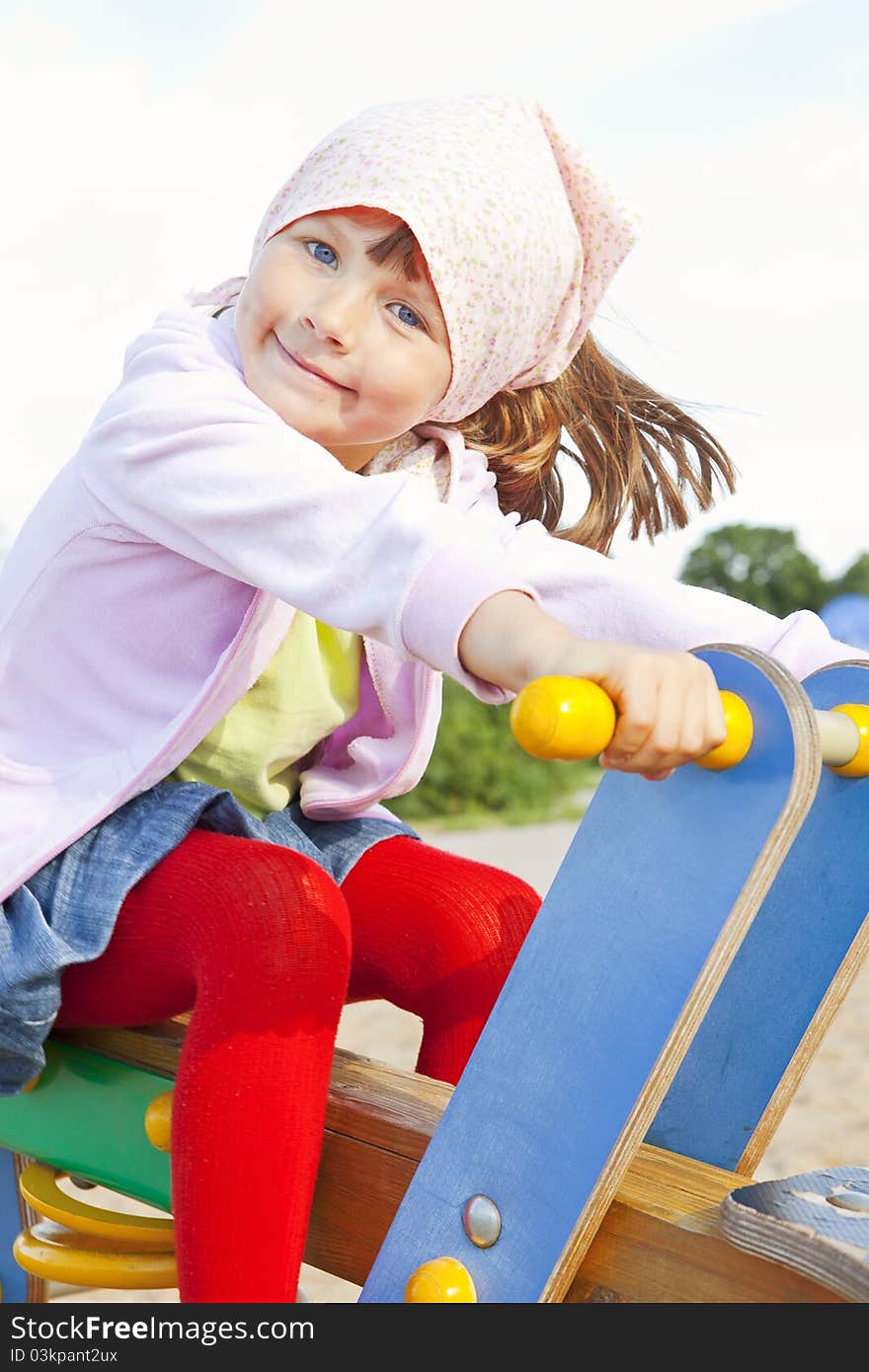 Small girl playing on children's playground