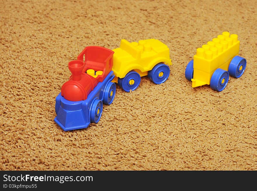 Small toy train on yellow background